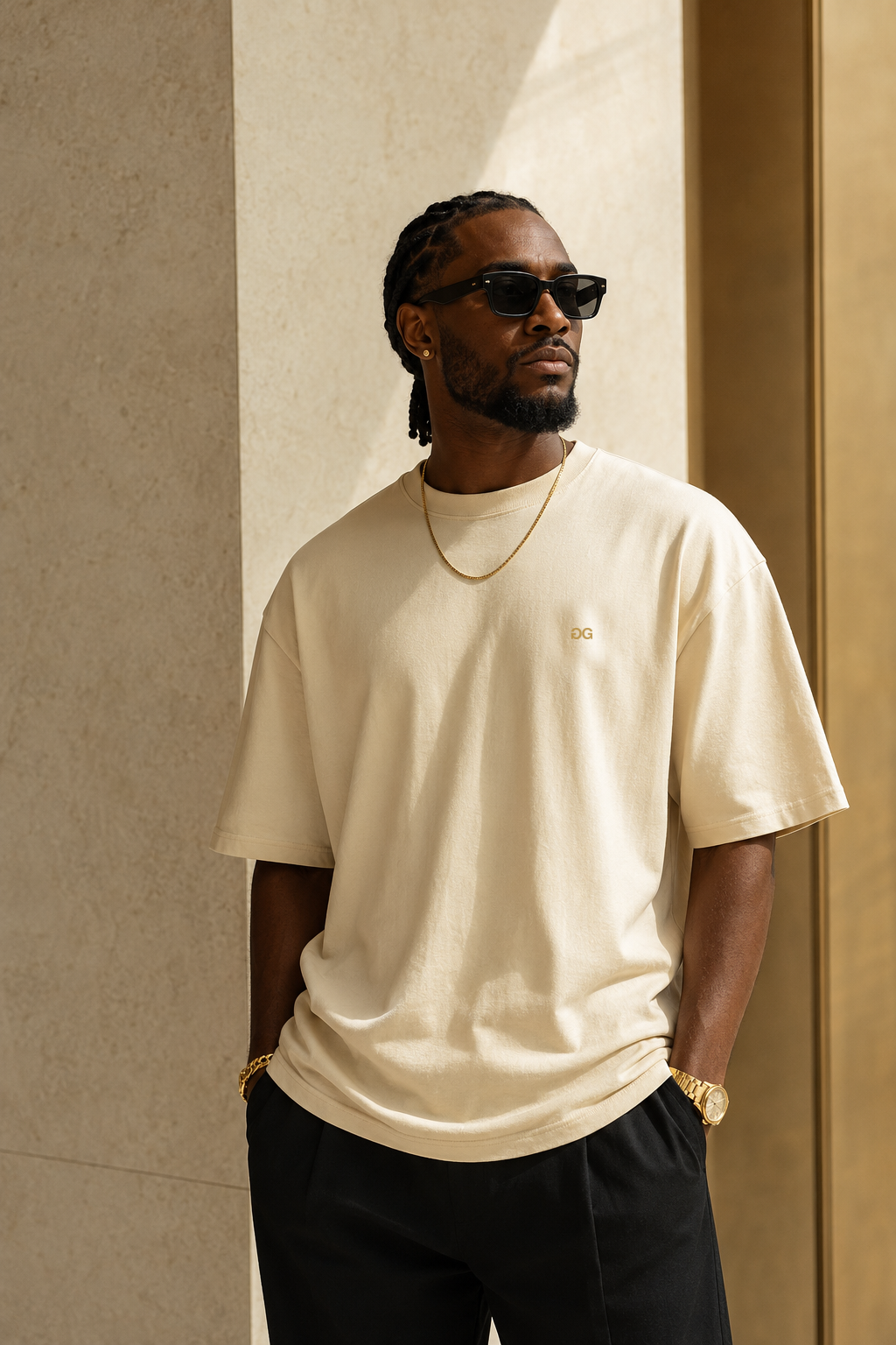 Black model wearing the cream heavyweight Drop 001 tee with gold details